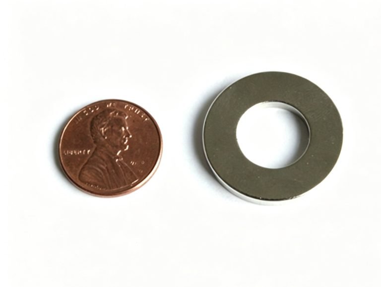 Sintered neodymium ring magnet for a 64-pole encoder beside a US penny for scale